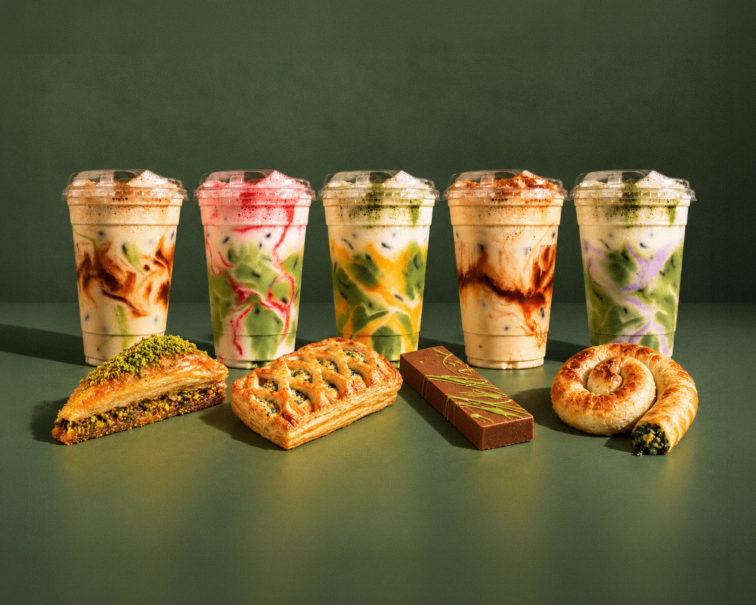 Colorful layered dessert cups with fruit, pistachio, chocolate, and creamy layers