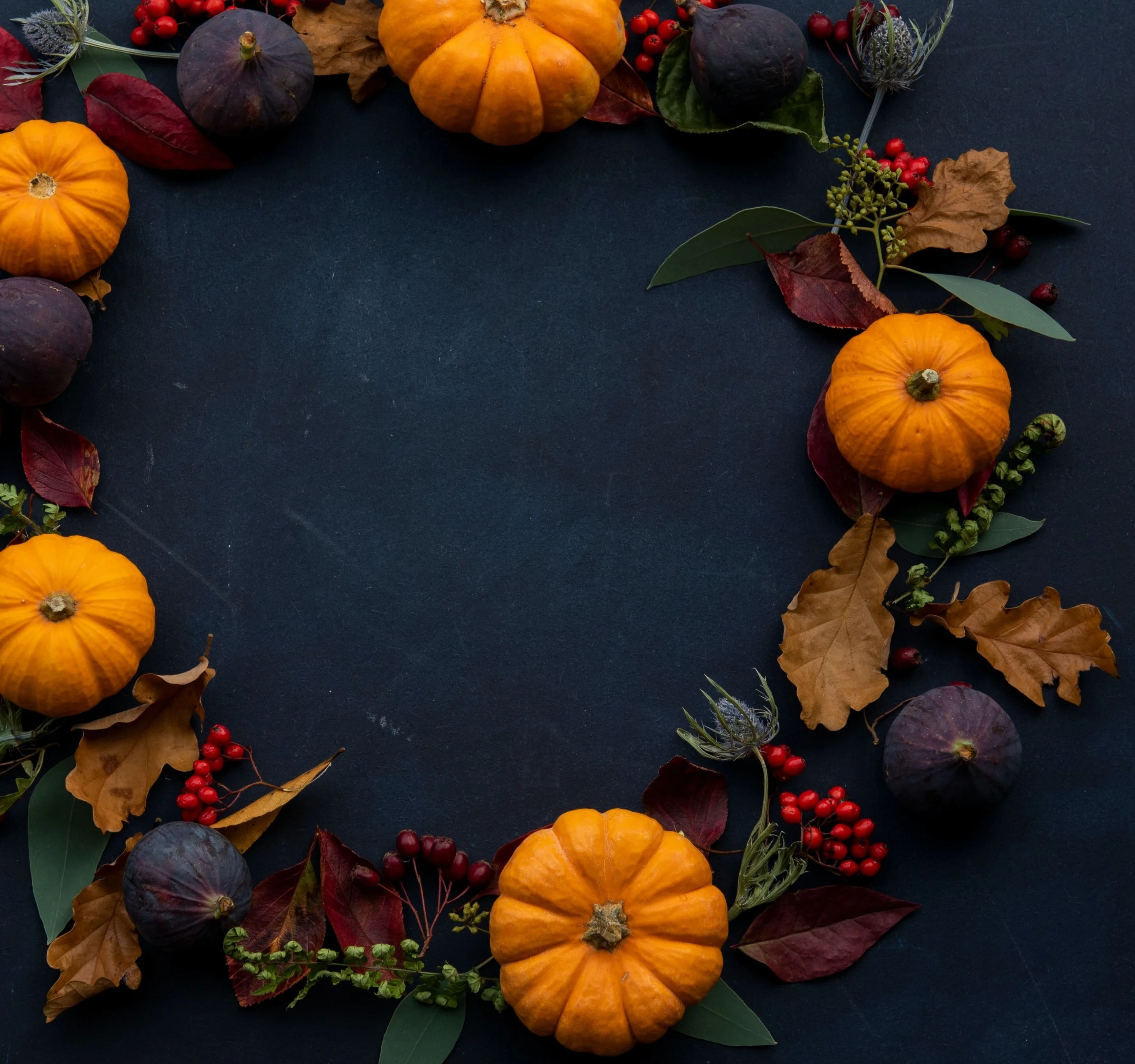 Autumn harvest of pumpkins, figs, berries, leaves, and botanical foliage