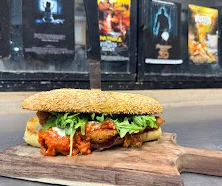 Spicy chicken sandwich with lettuce on a wooden board
