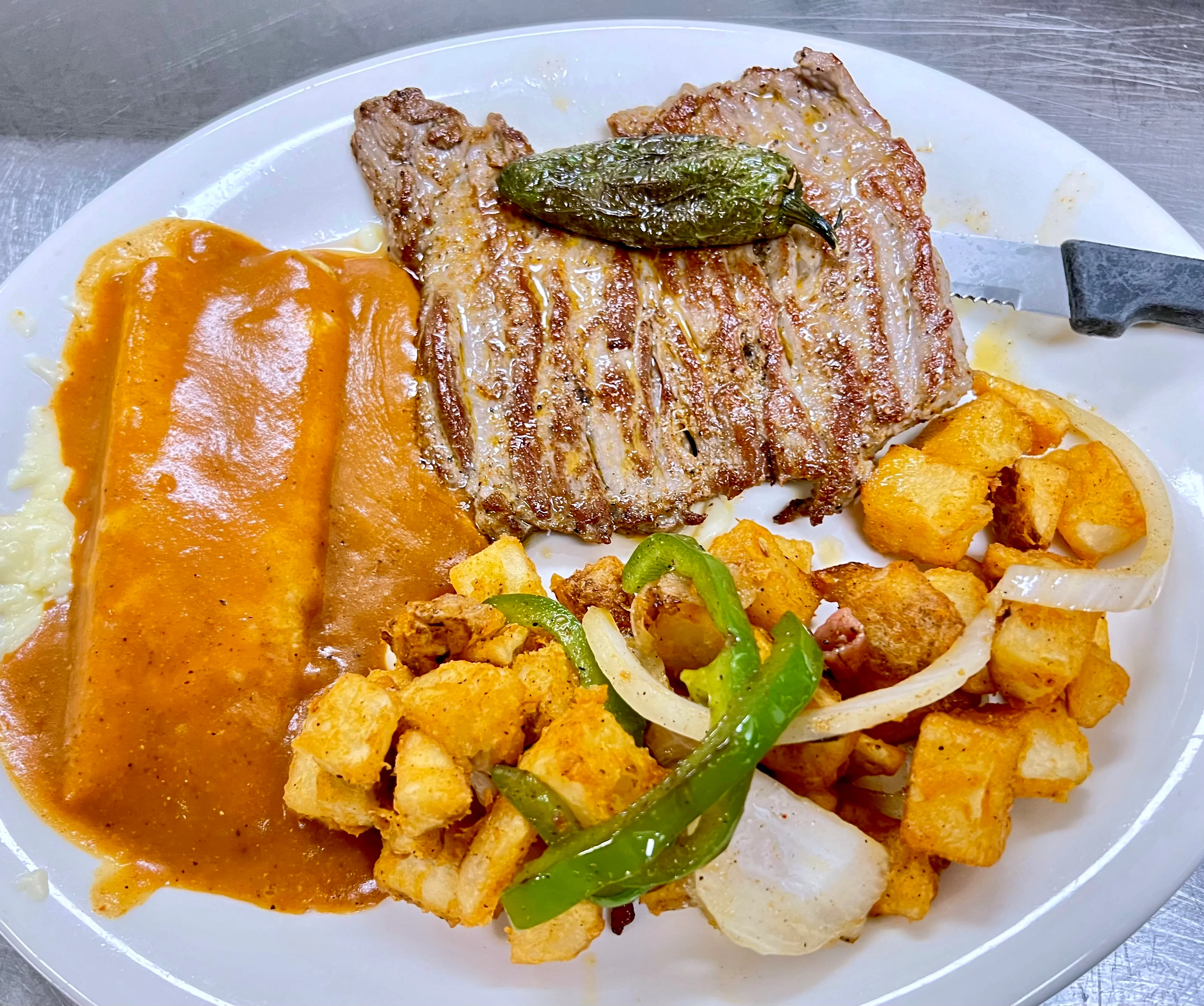 Grilled carne asada with enchiladas and seasoned potatoes