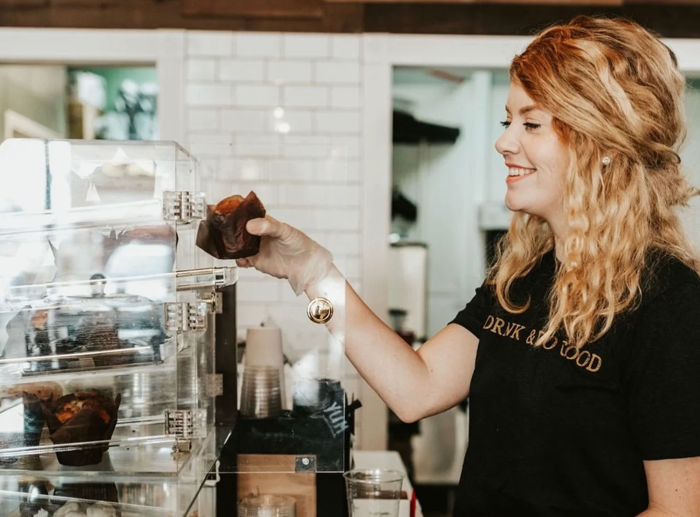Barista serving freshly baked muffins in a cozy café