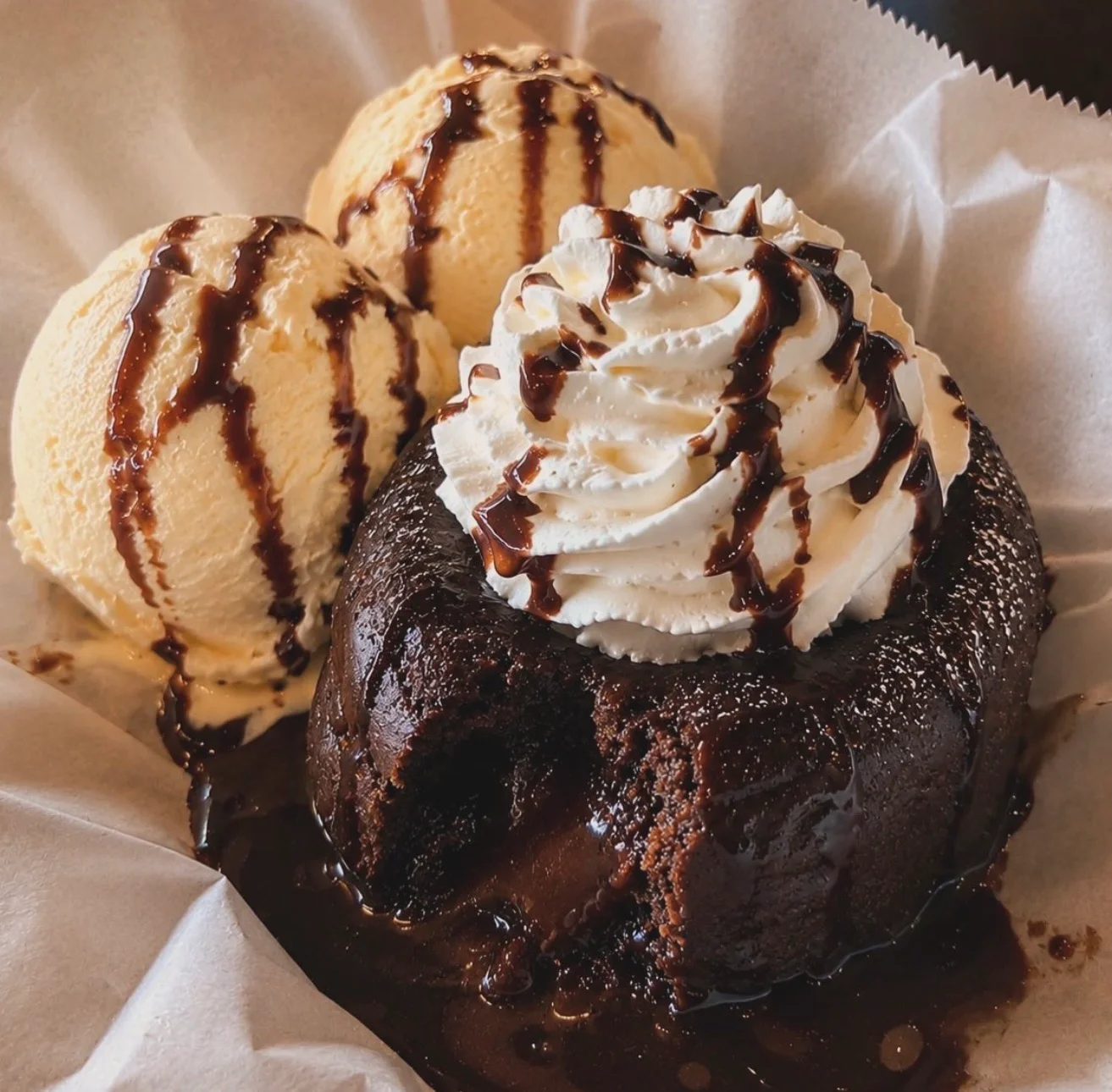 Decadent chocolate lava cake with vanilla ice cream and whipped cream