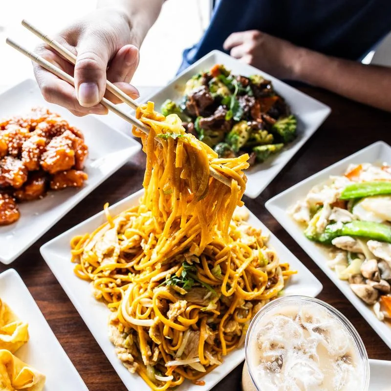 Assorted Chinese dumplings and spring rolls on a wooden table