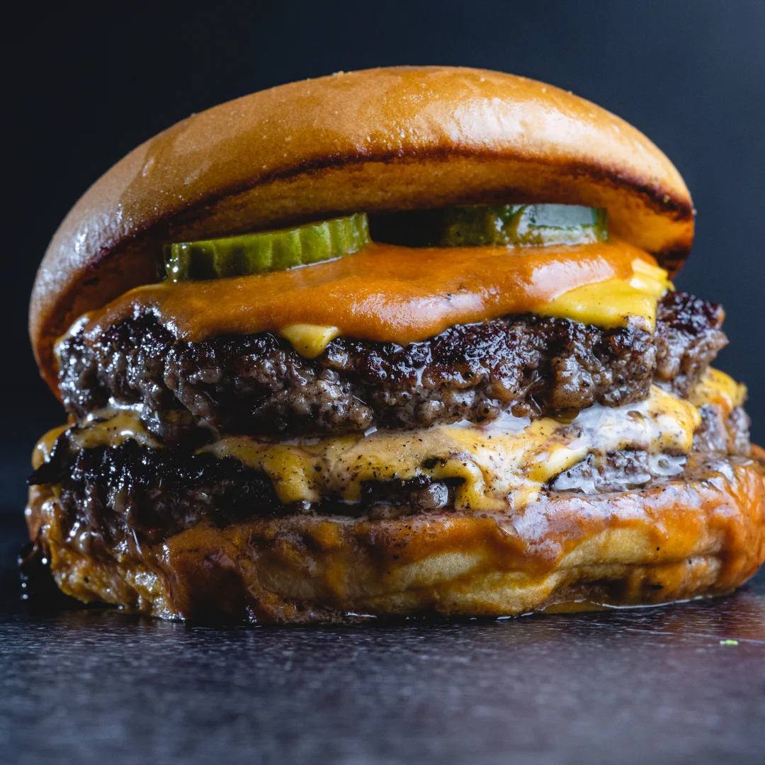 Juicy double cheeseburger with pickles and melted cheese