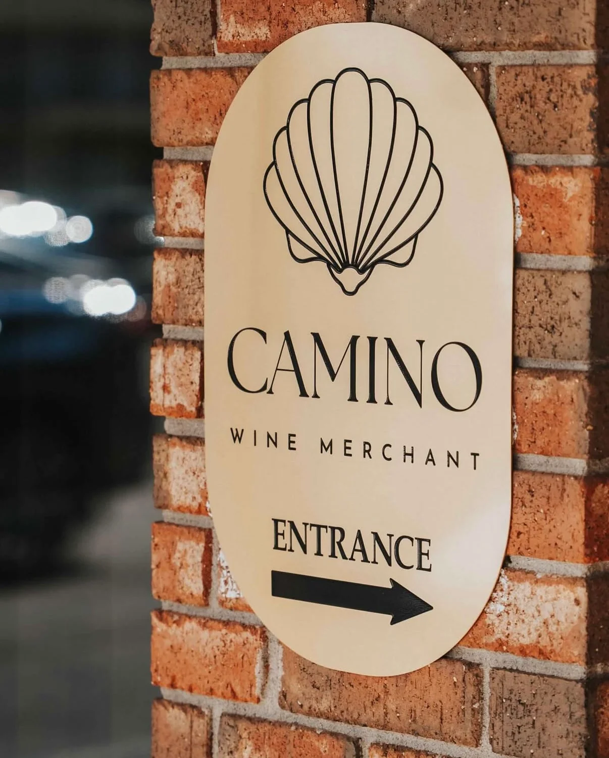 Sign for Camino Wine Merchant with entrance direction