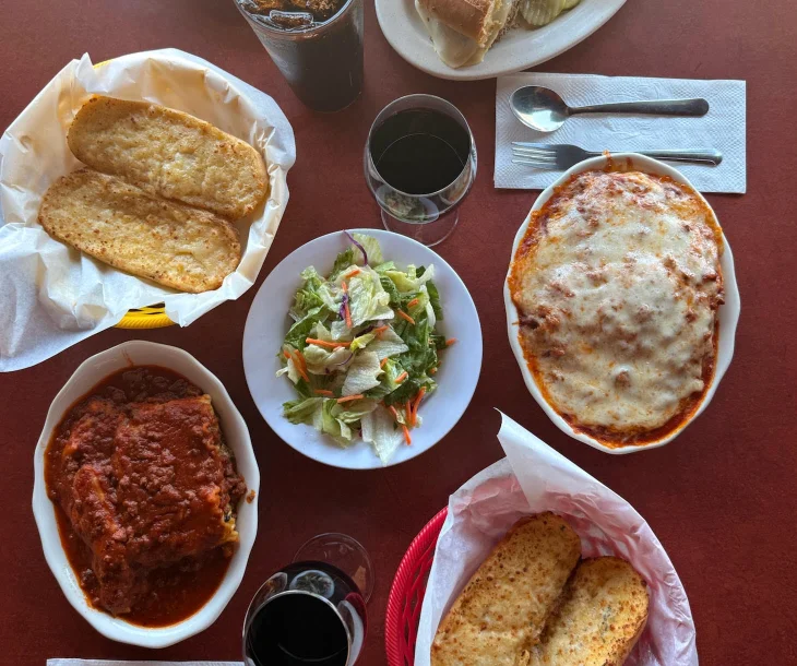 Italian lasagna with garlic bread and fresh salad on a restaurant table