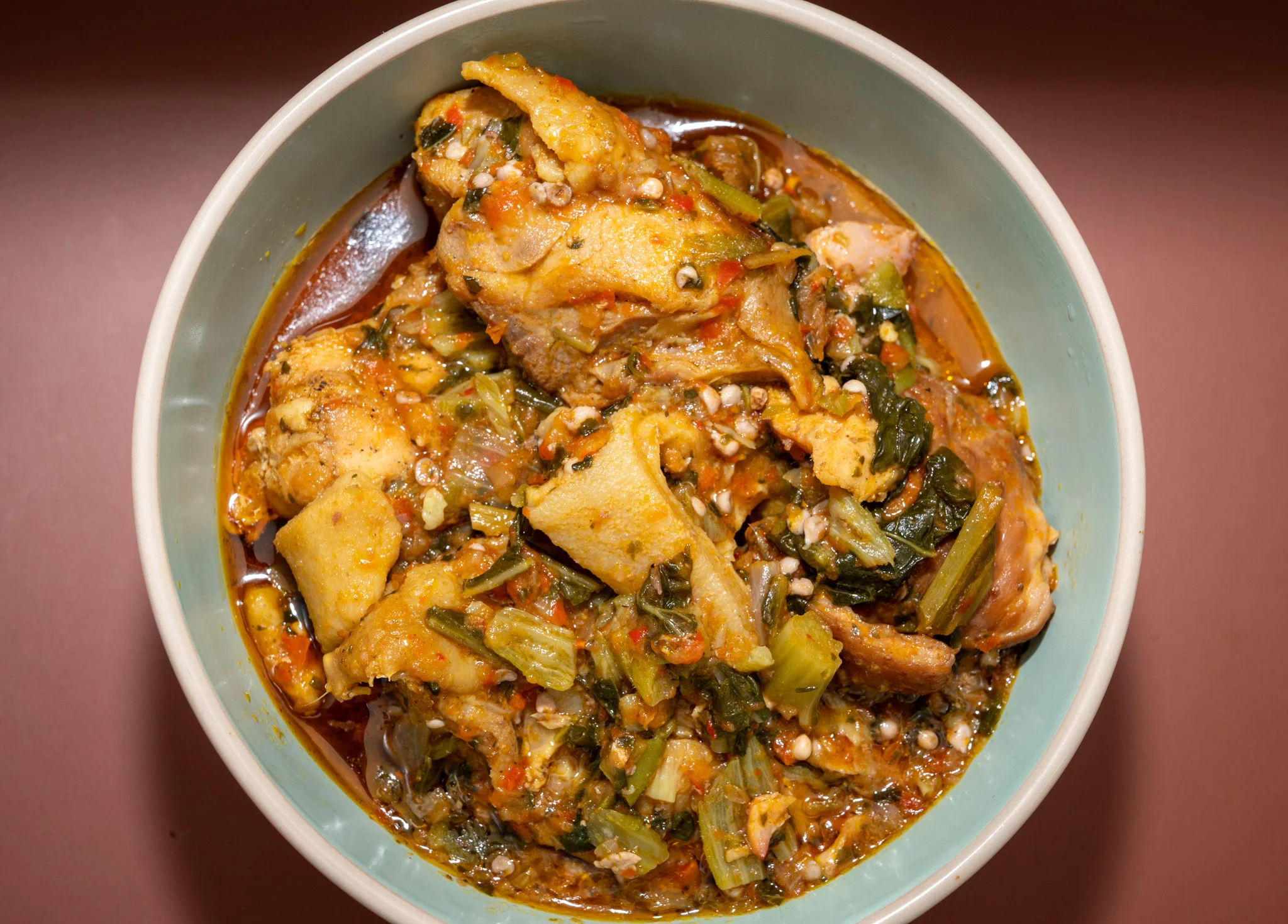 A bowl of traditional Okro soup with vibrant green okra and spices.