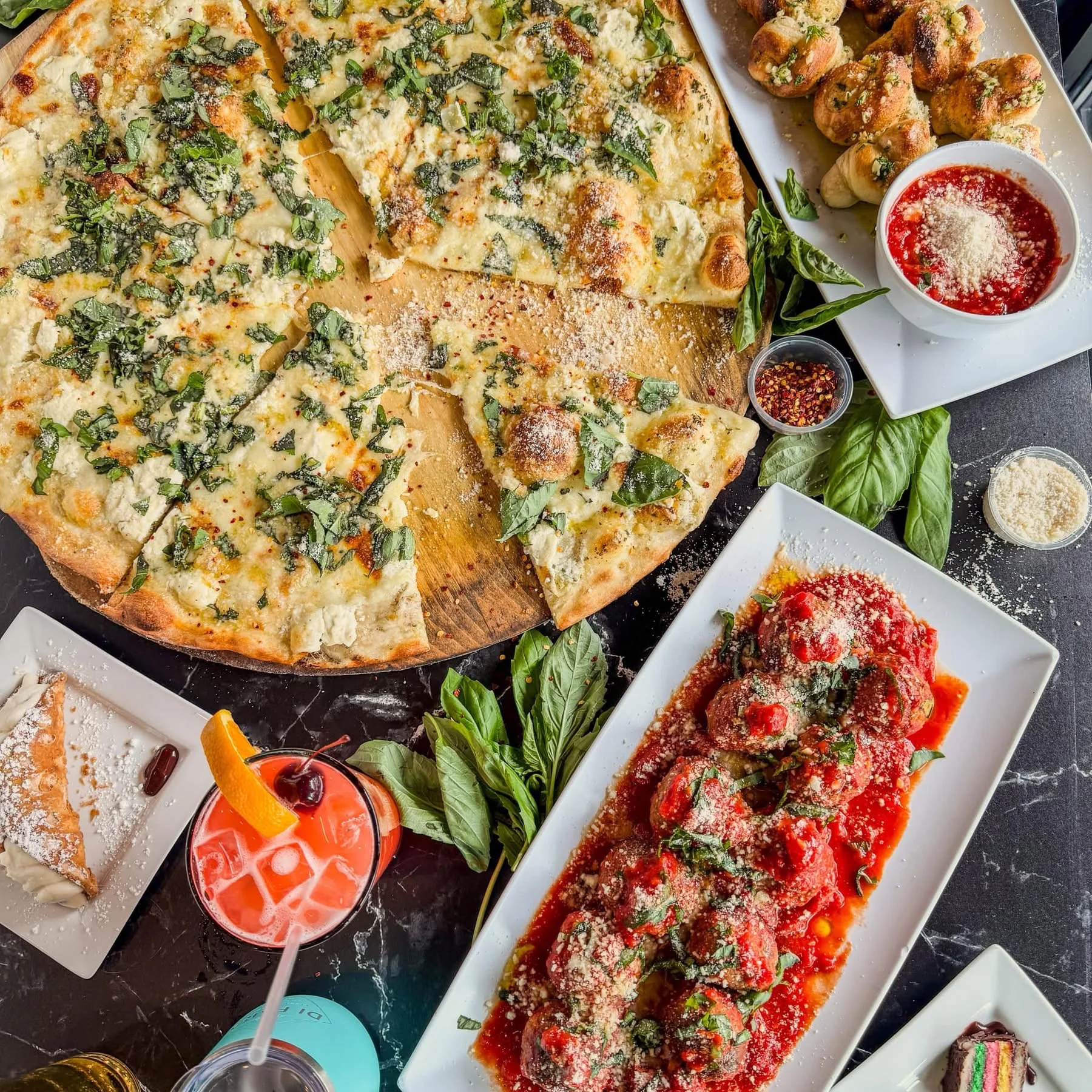 A vibrant display of various food and drinks on a restaurant table.