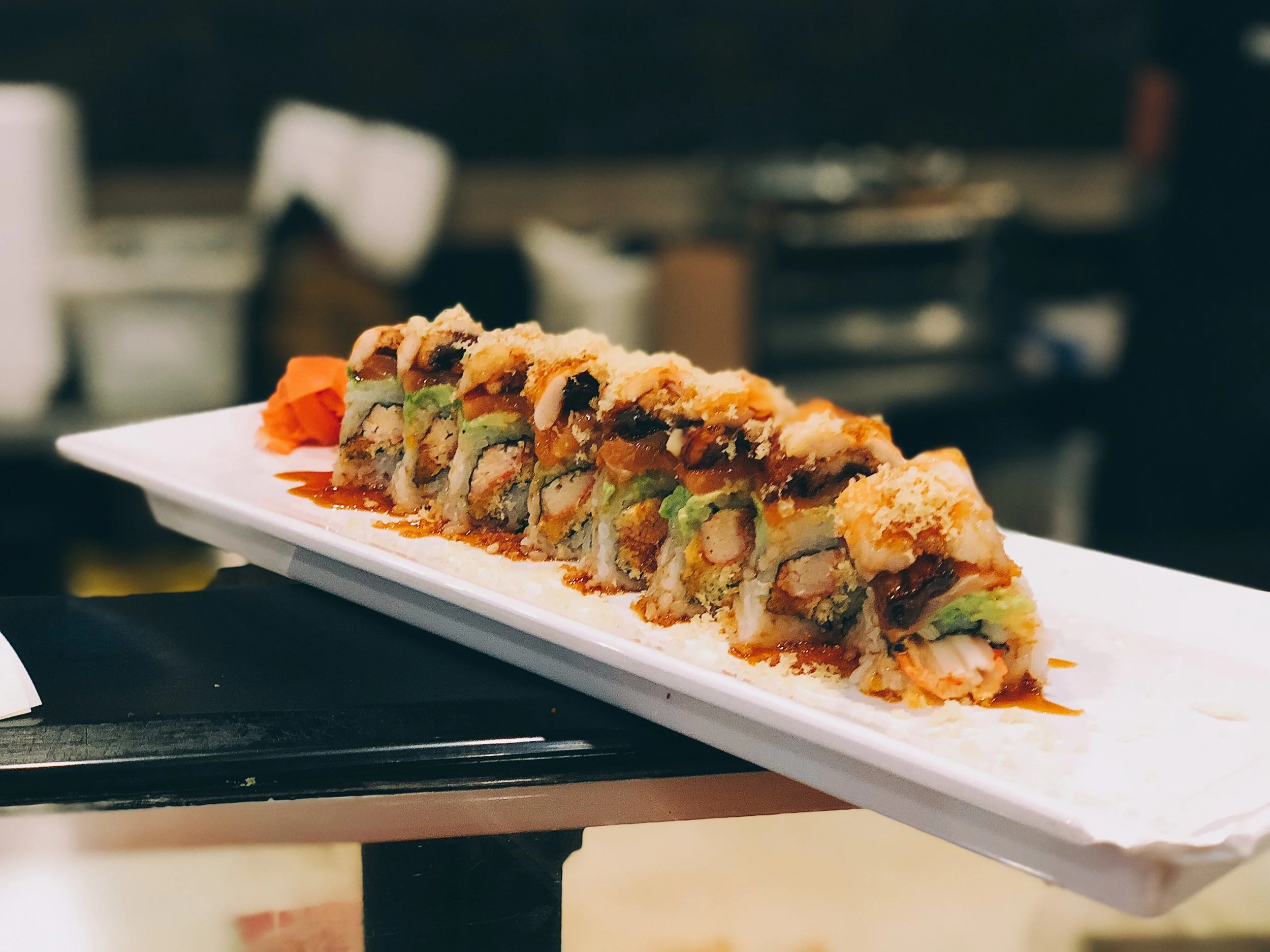 Japanese sushi roll with colorful layers and garnishes