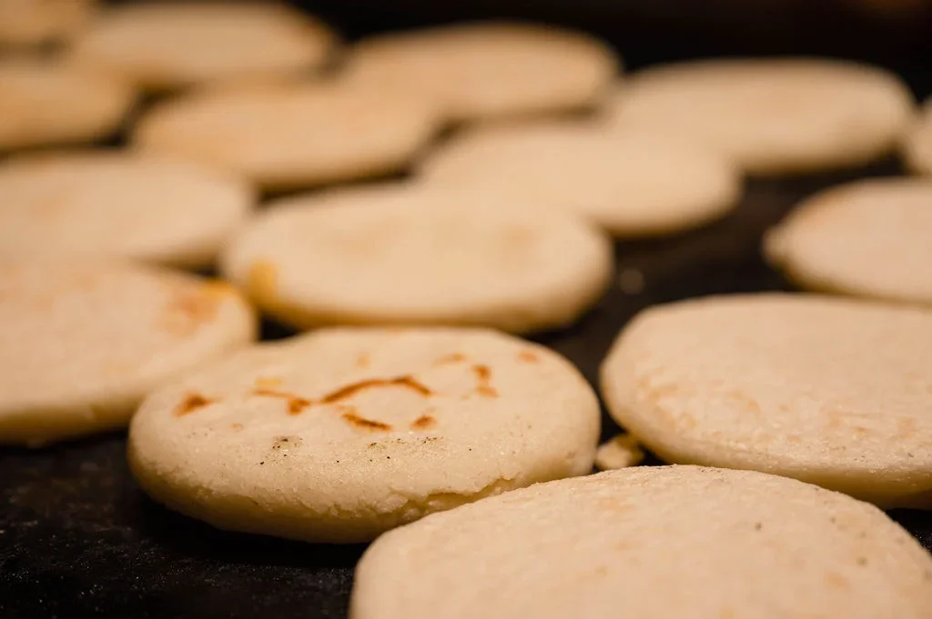 Freshly cooked arepas on a griddle