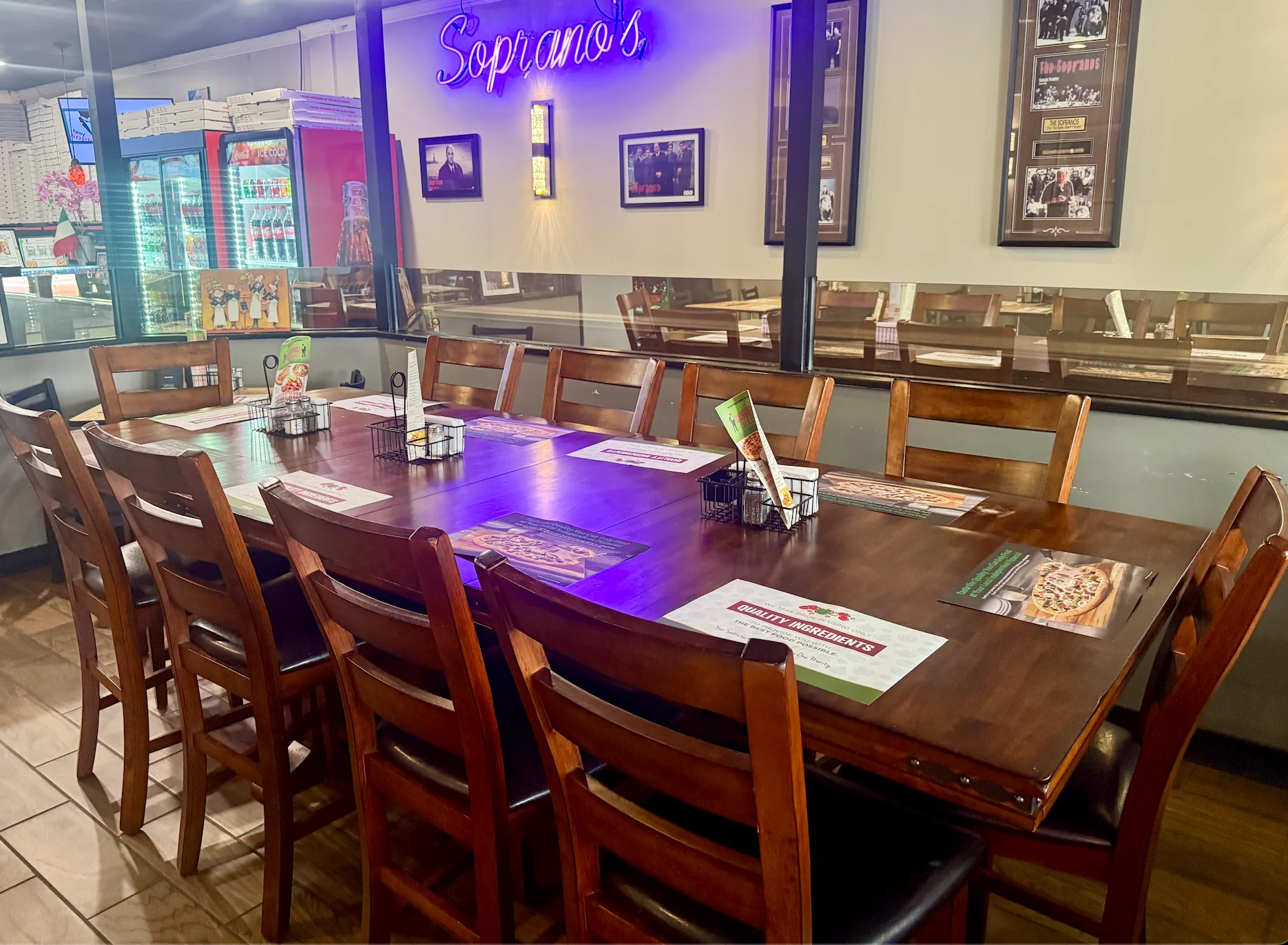 Soprano's Italian restaurant dining room with wooden tables and purple neon signage
