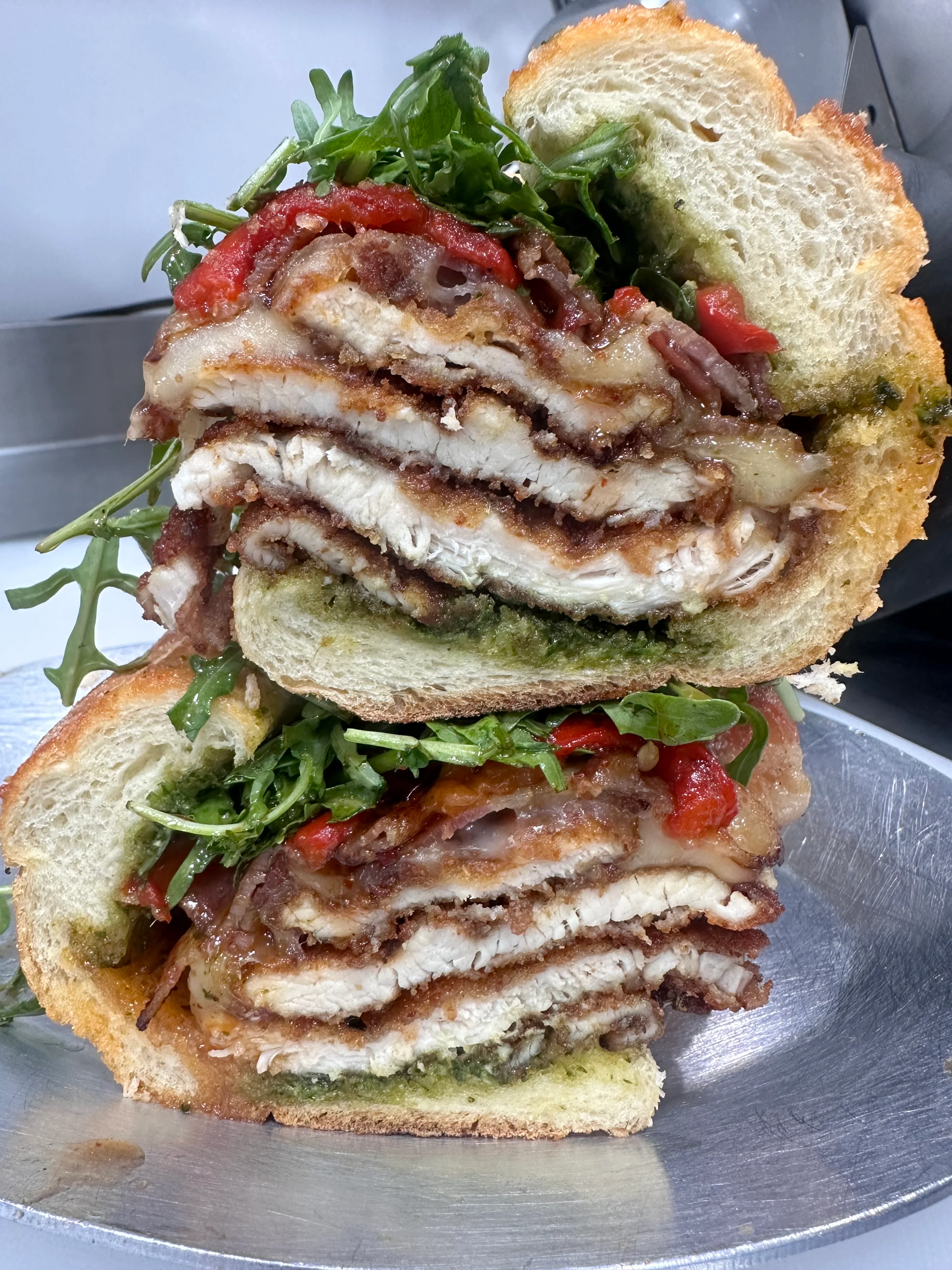 Italian chicken parmigiana sandwich stacked high with greens