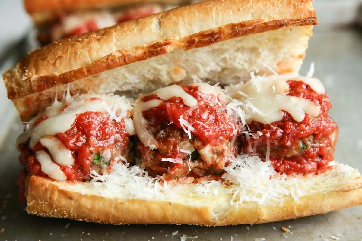Meatball sub sandwich with marinara sauce and cheese on a toasted bun.