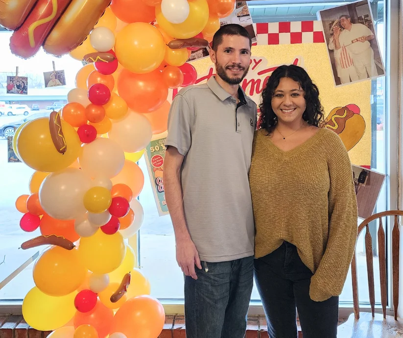 Cheerful restaurant celebration with colorful balloon arch