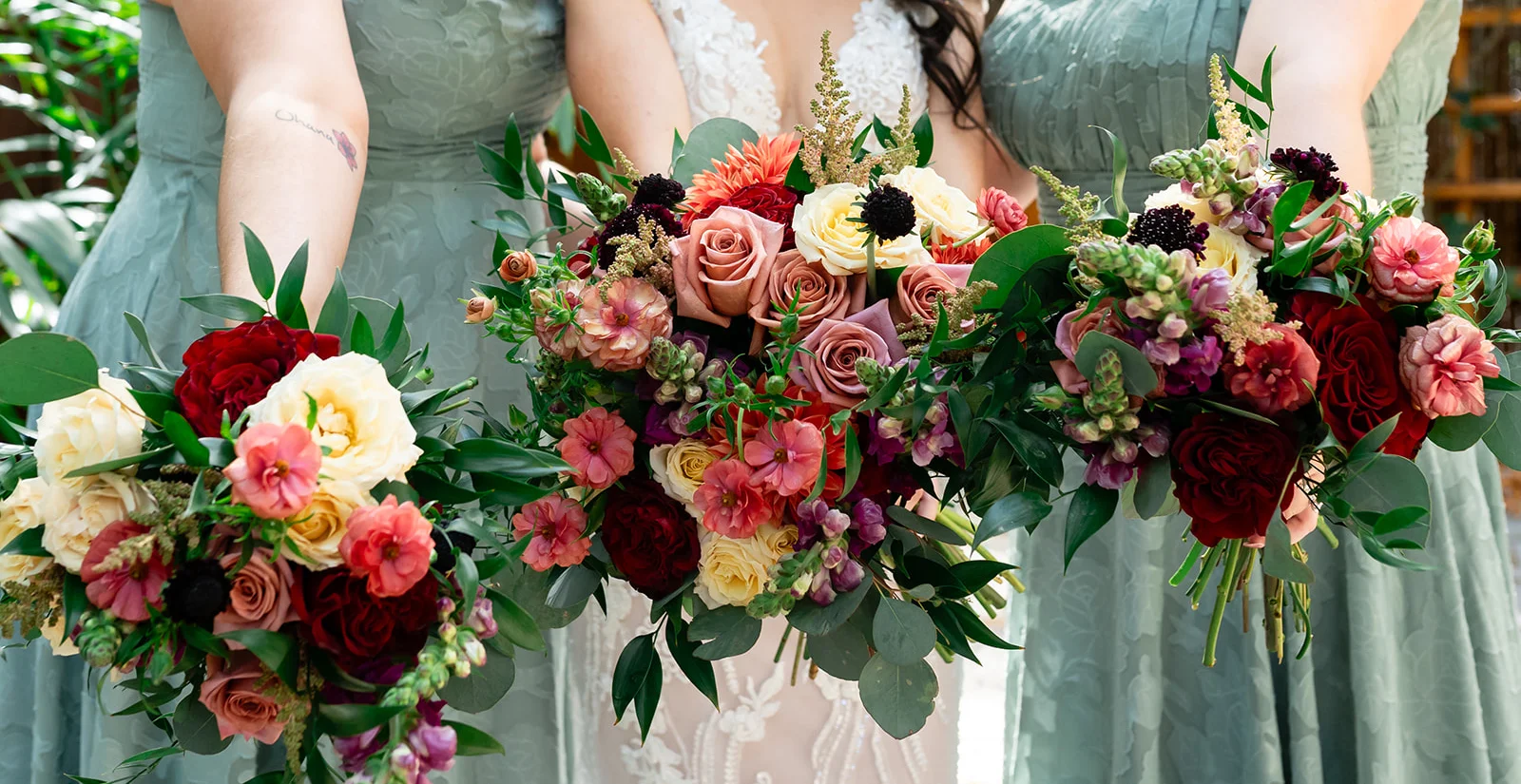 Bridal party showcasing vibrant floral bouquets in a garden setting