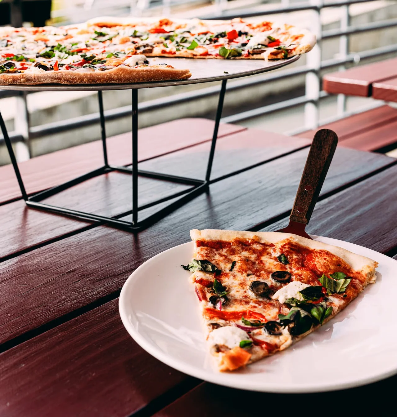 slice of primavera pizza on patio