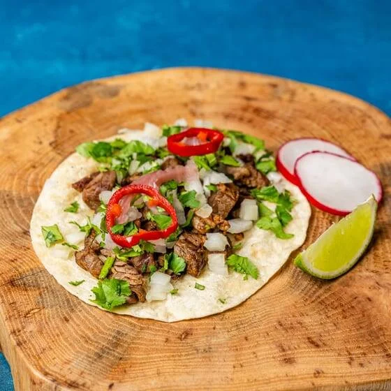 Cut-open Mexican burrito served on a wooden board