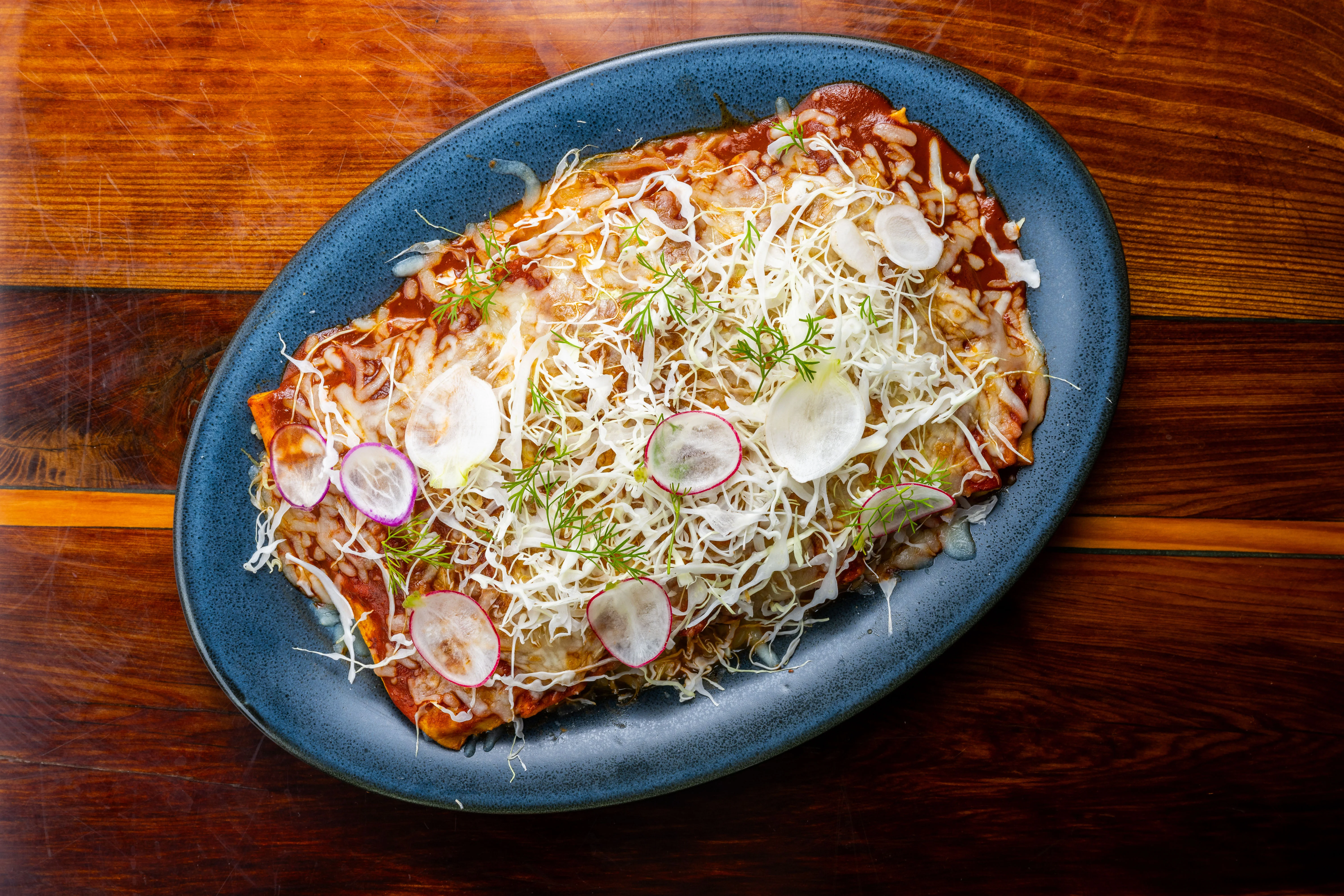 Delicious Mexican enchiladas topped with fresh vegetables