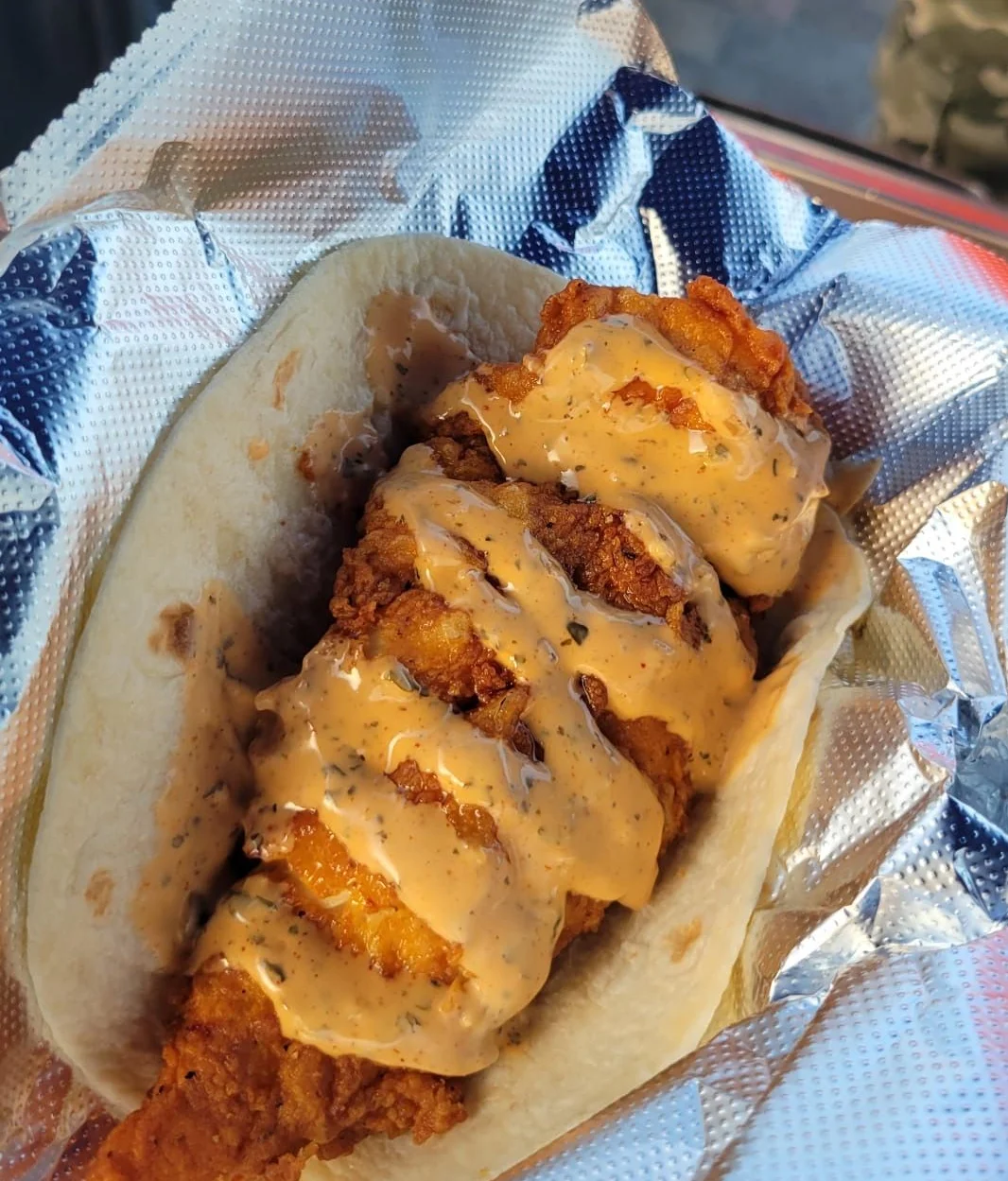 Fish Fried Taco topped by one of  Doz DHR's speciality spicy sauces.