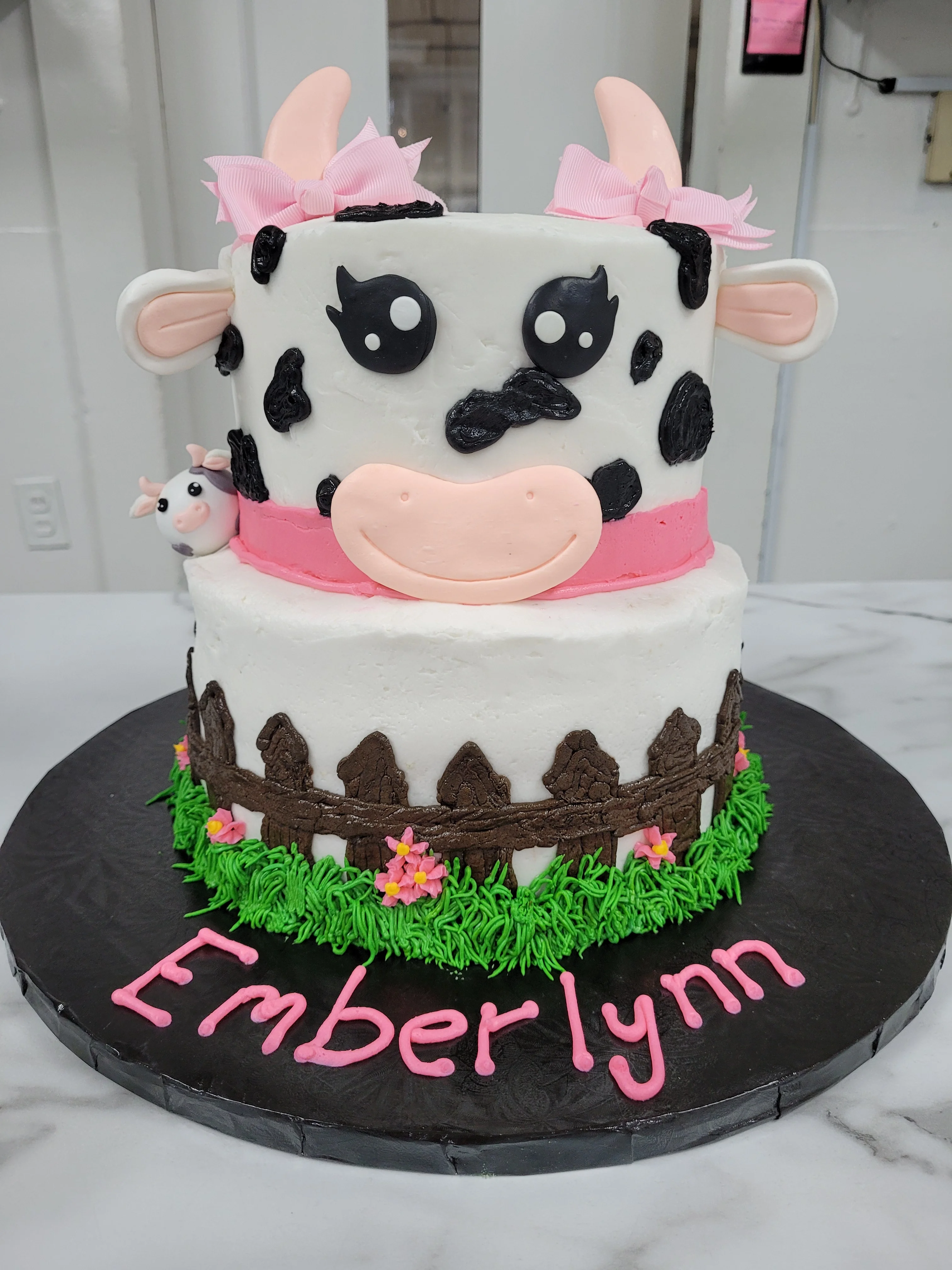 Adorable cow-themed birthday cake with pink accents
