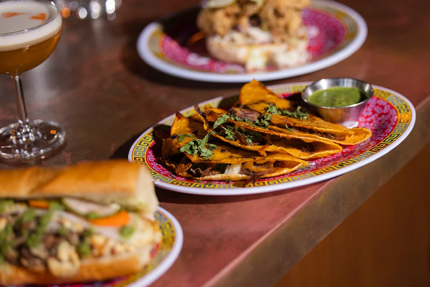 Plate of Mexican tacos with cilantro and green salsa