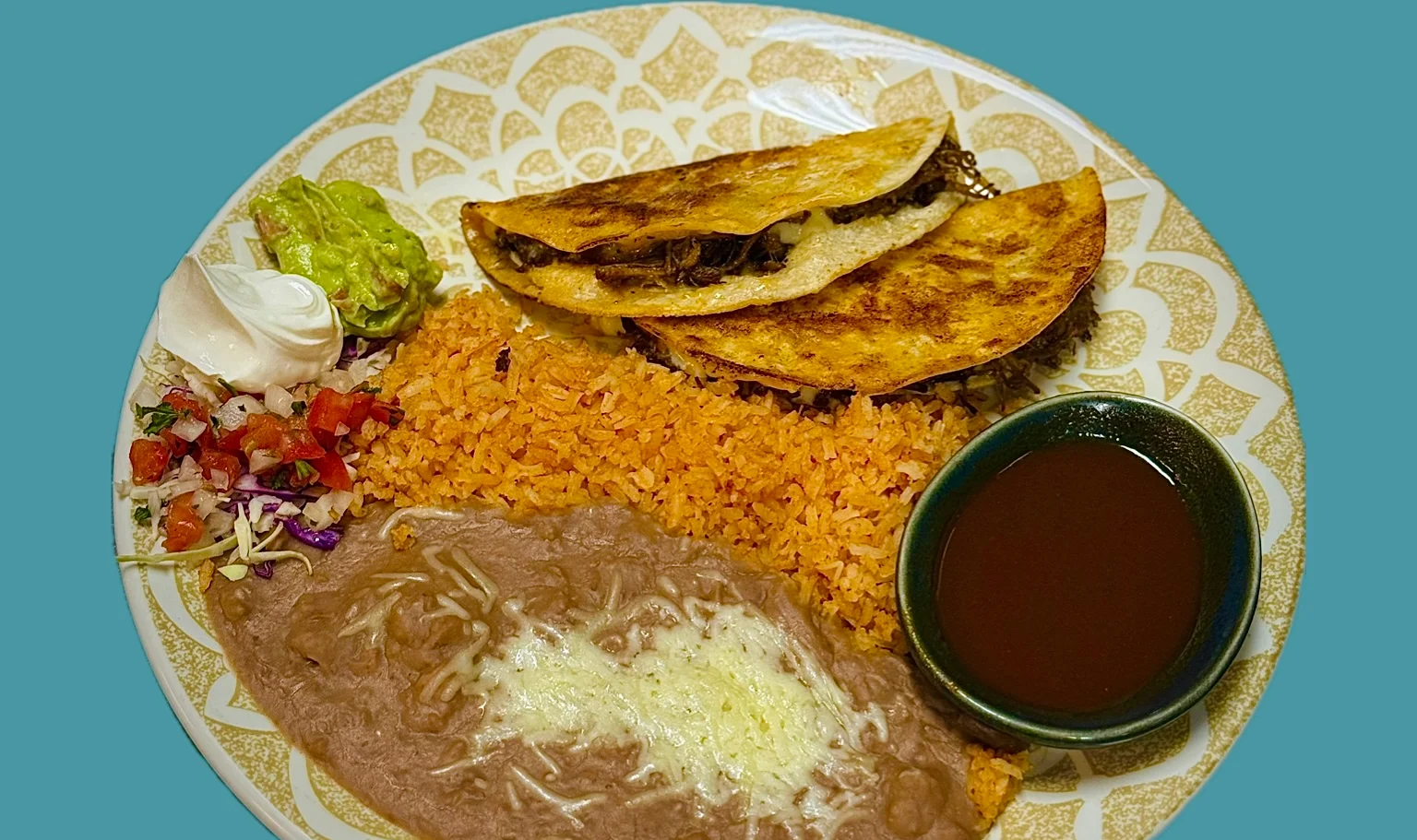 Plate of Mexican tacos with rice, beans, and salsa