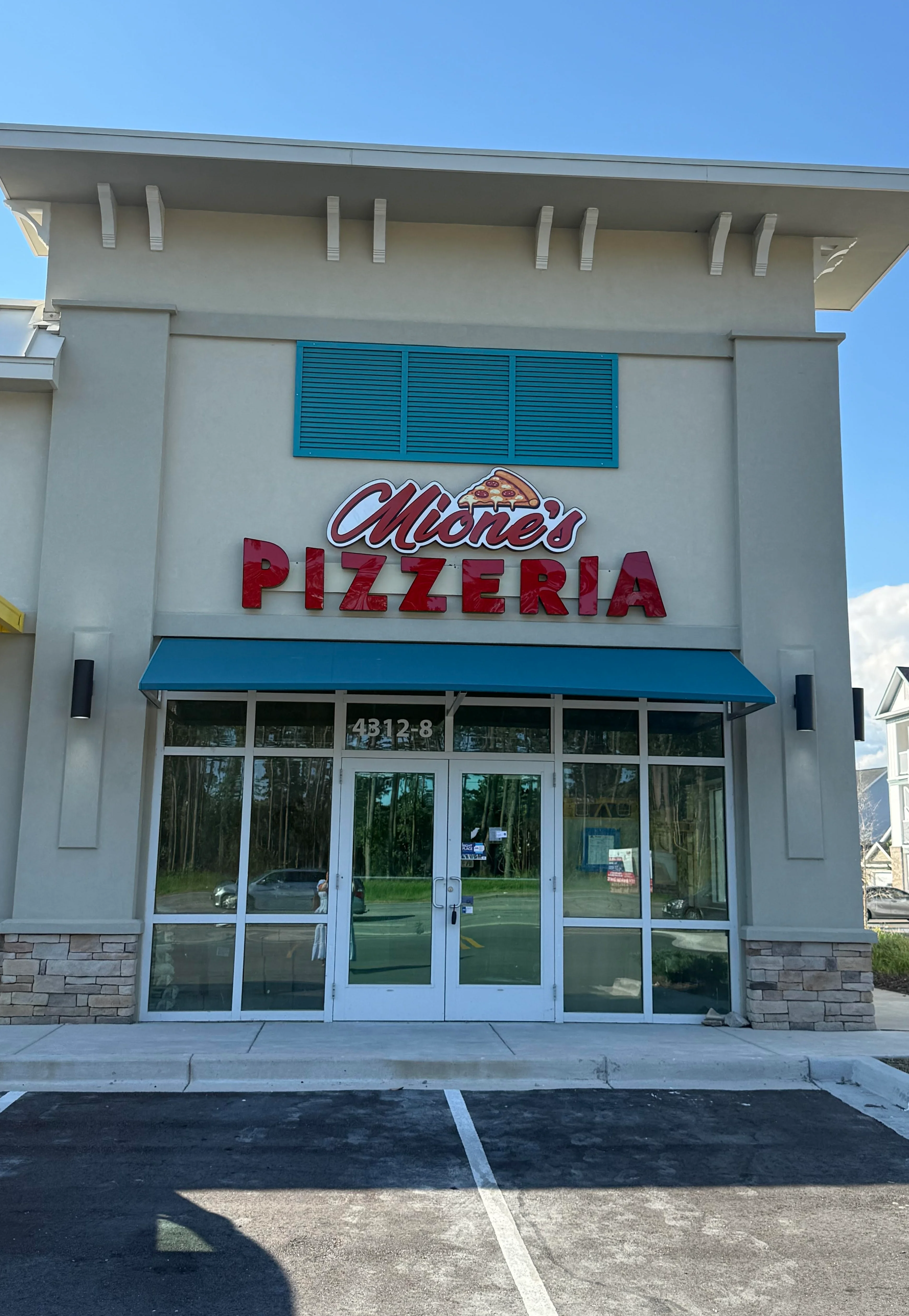Exterior view of a pizzeria with bright signage