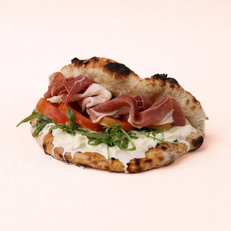 Italian focaccia sandwich with prosciutto and fresh vegetables