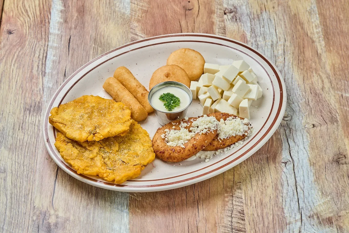 Plate of Colombian arepas with cheese and fried plantains