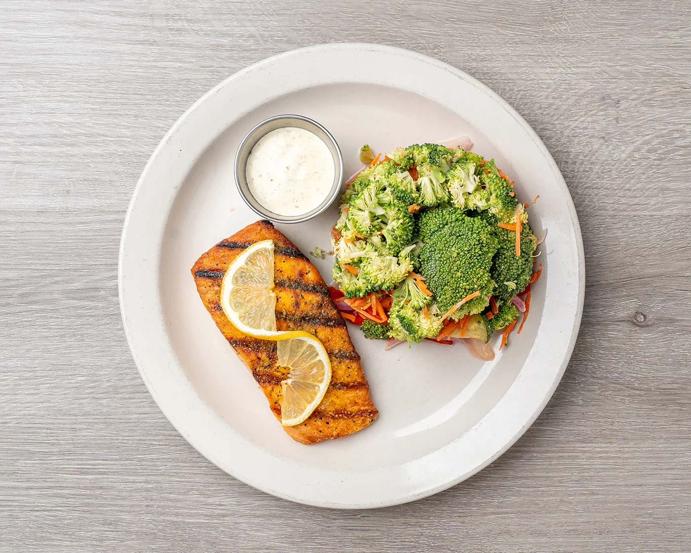 Grilled salmon fillet served with vegetables on a white plate