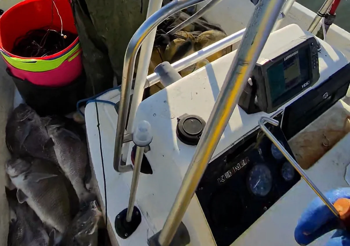 Fisherman preparing catch on a boat in calm waters