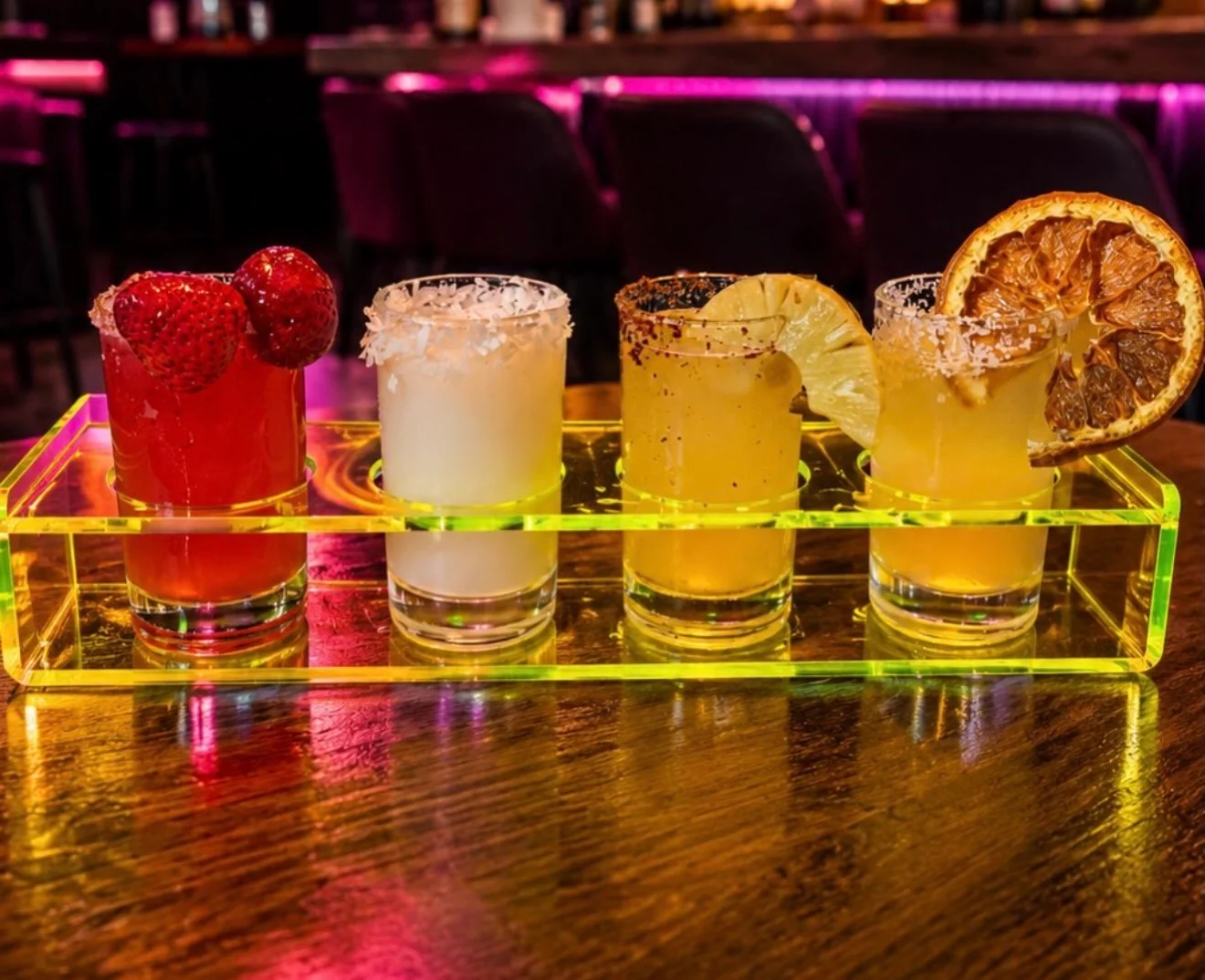 Colorful cocktail flight with vibrant garnishes at a modern bar
