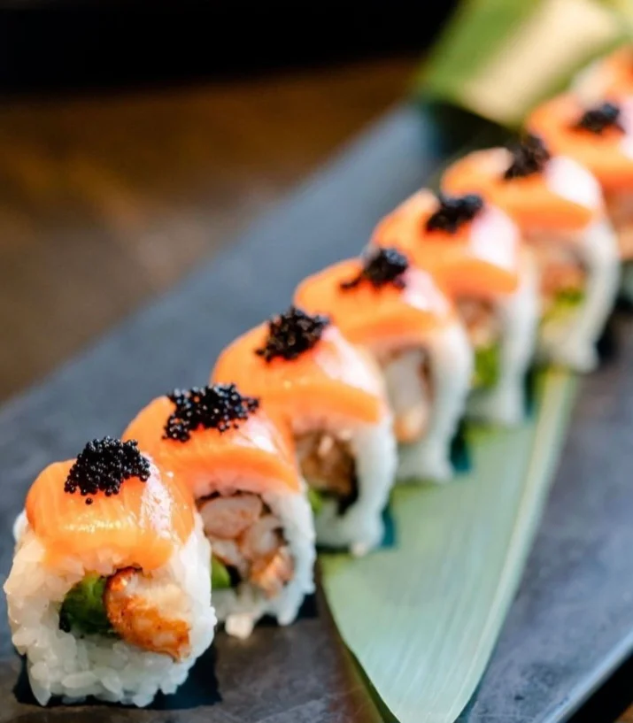 Japanese sushi rolls topped with salmon and caviar