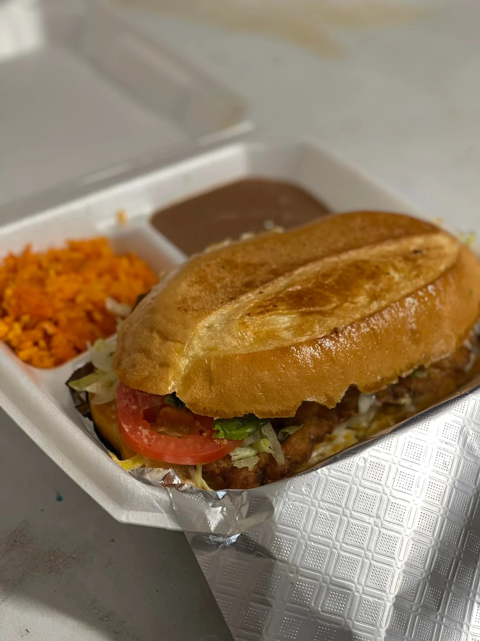 Mexican torta with beans and rice on the side
