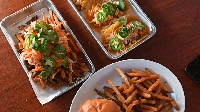 Loaded fries and tacos with jalapeños in a casual dining setting