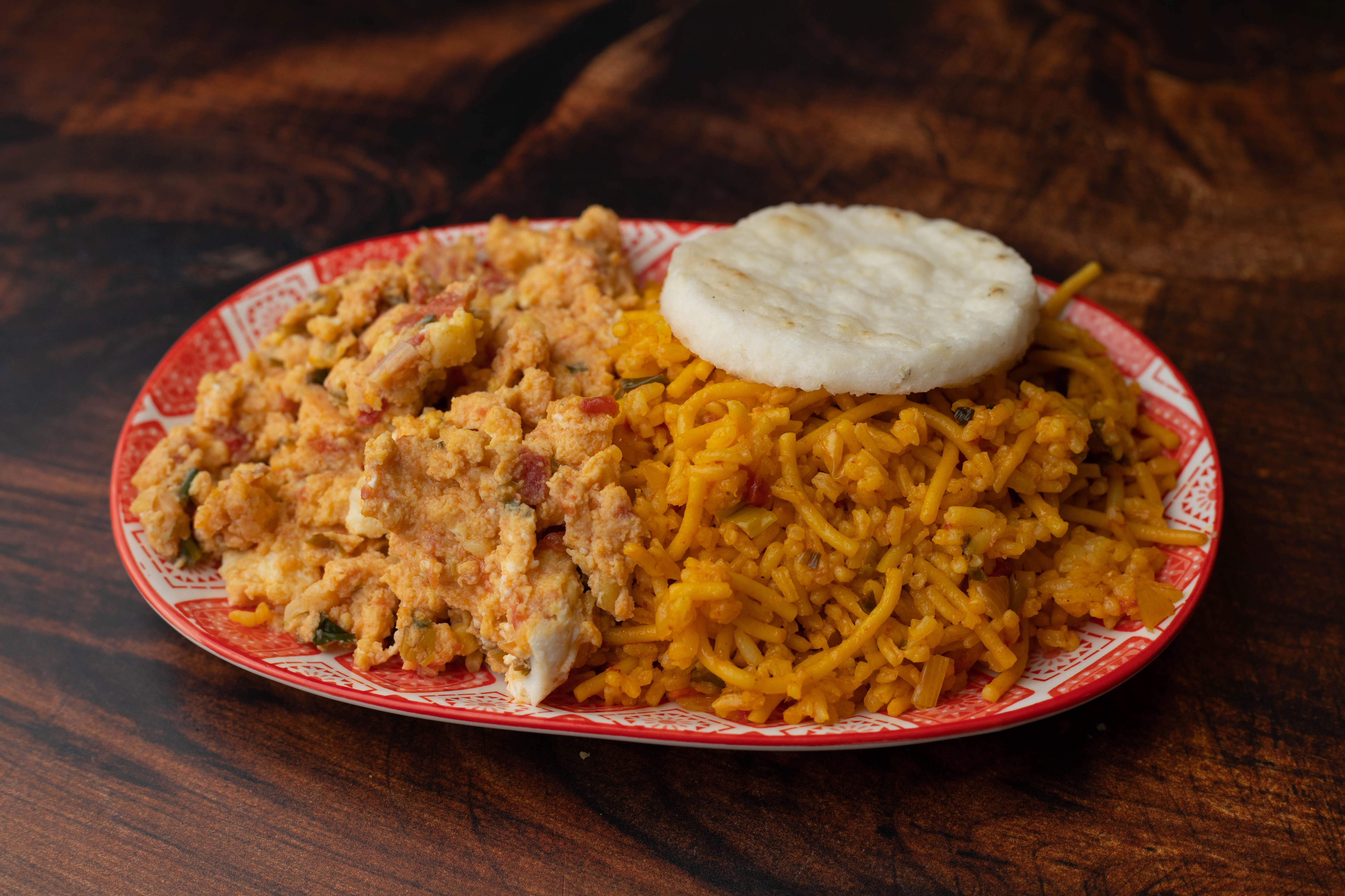 Nigerian jollof rice with scrambled eggs and fried plantain