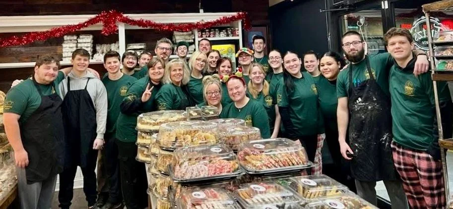 Team of bakers in a cozy bakery with festive treats