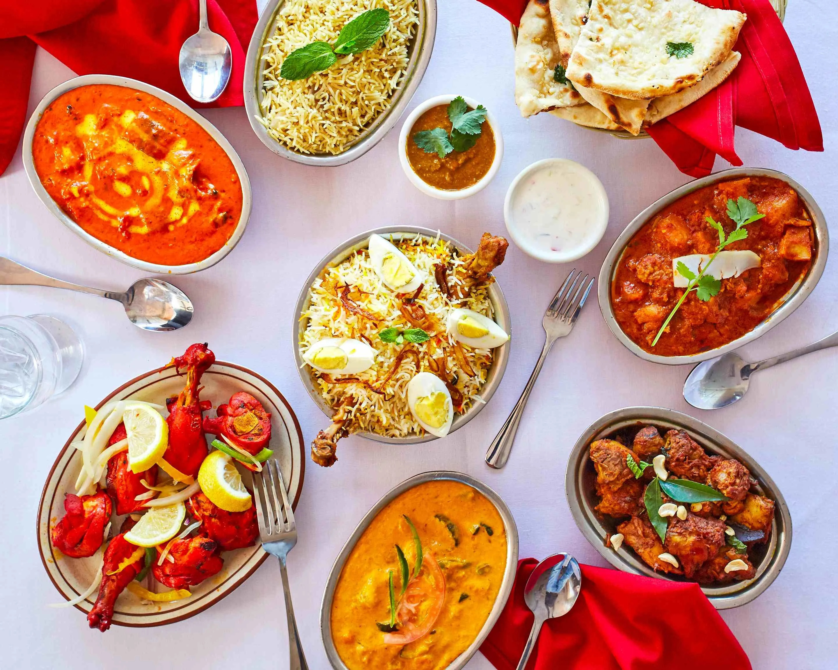 Assorted Indian curries and biryani served with naan and raita