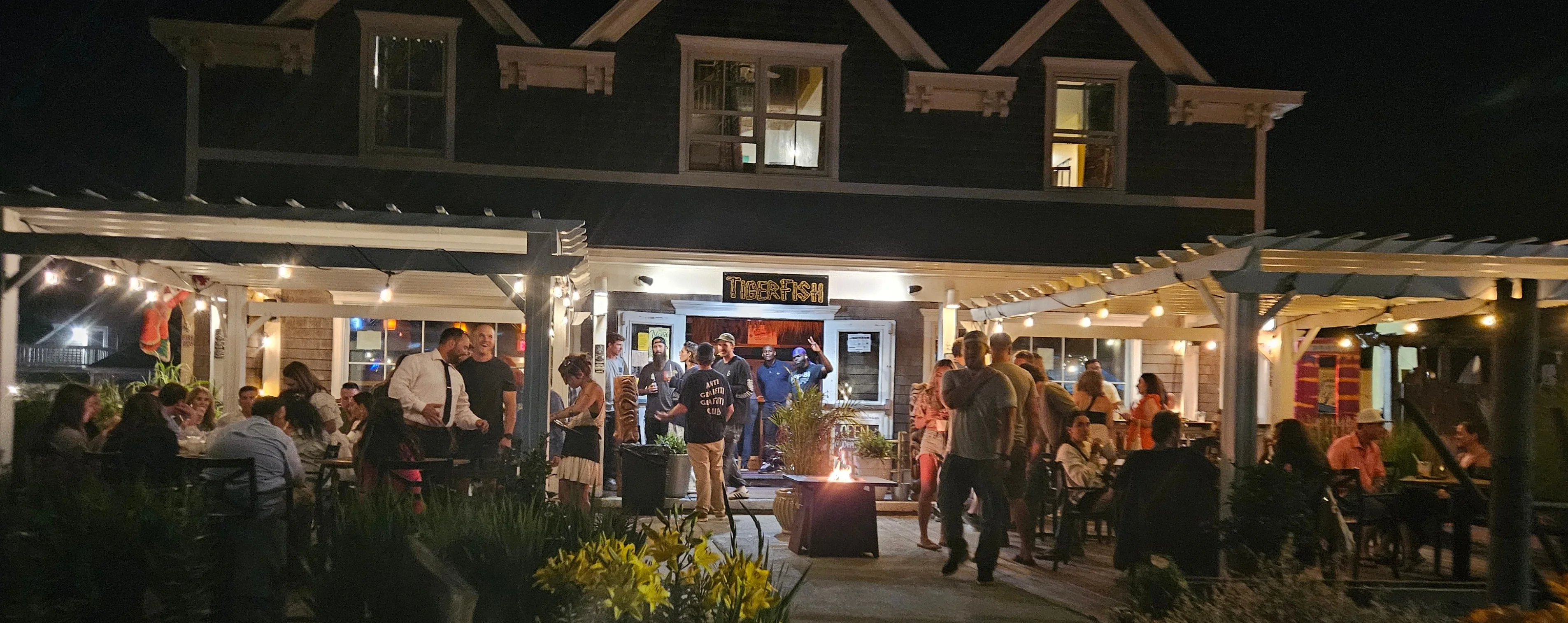 Lively restaurant exterior with outdoor seating at night