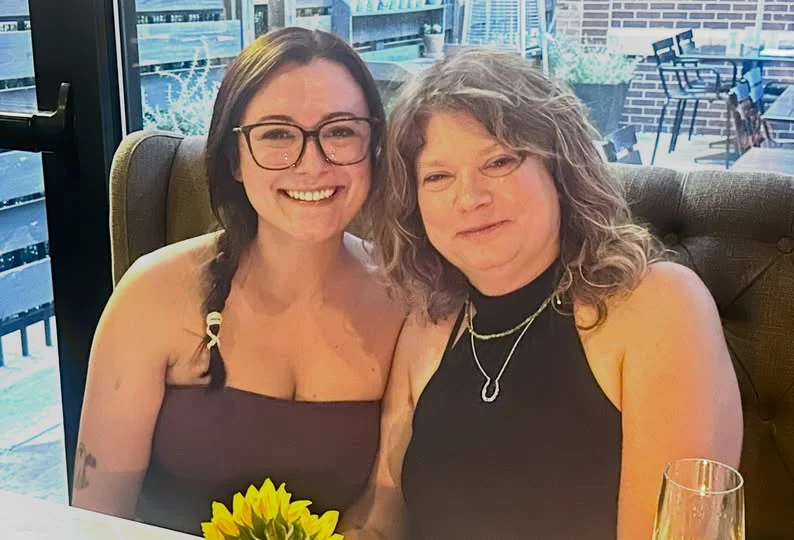 Two women smiling together in a cozy restaurant setting