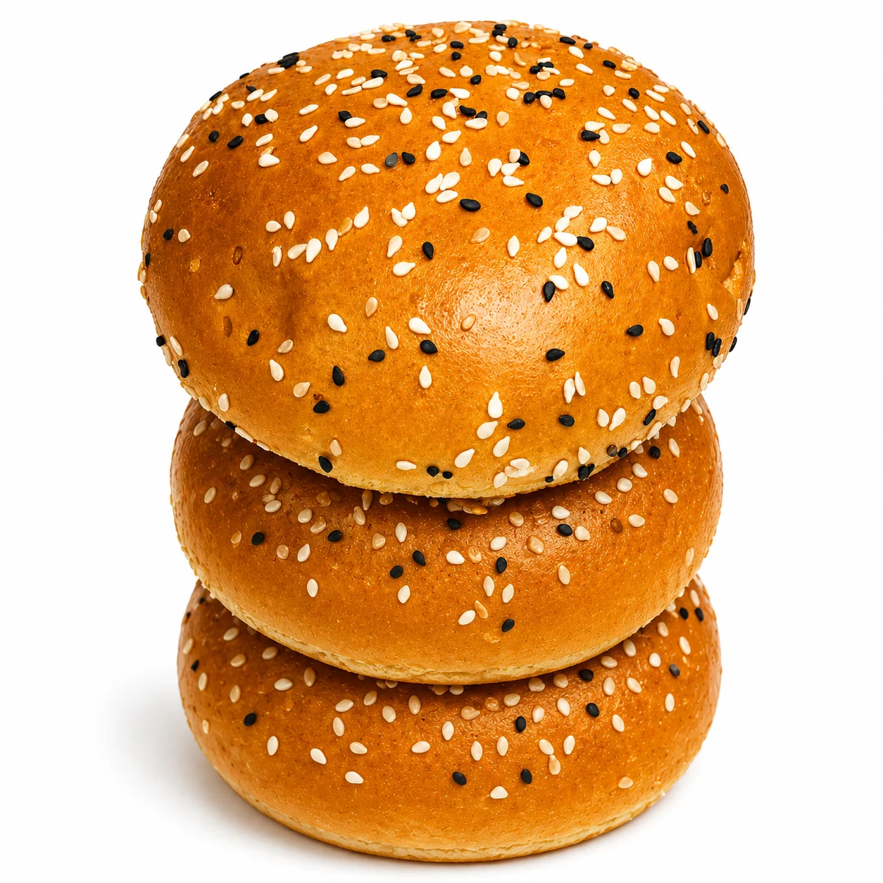 Three sesame seed burger buns stacked on top of each other.