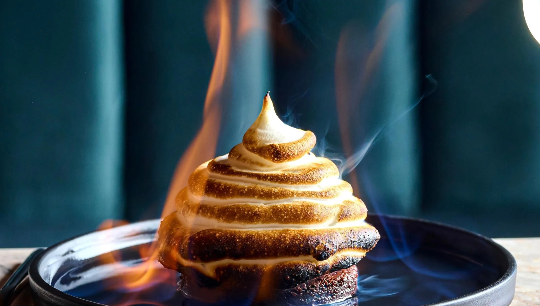 Flaming baked Alaska dessert with cocktail