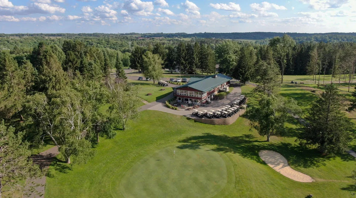 Aerial view of a golf course clubhouse surrounded by lush greenery