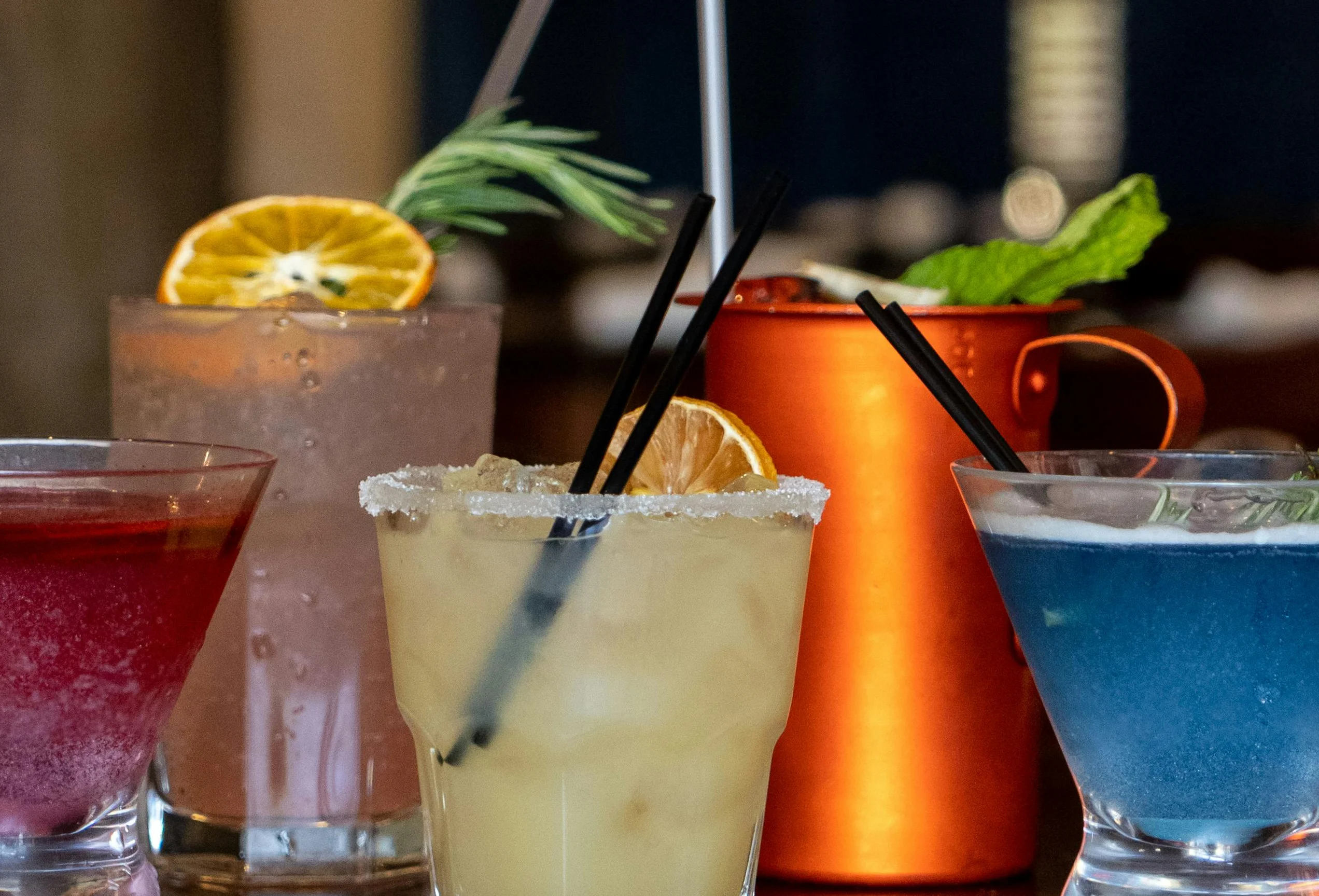 Colorful cocktails on a wooden bar counter