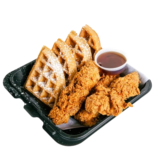 A plate featuring crispy fried chicken accompanied by waffles and a small cup of syrup.