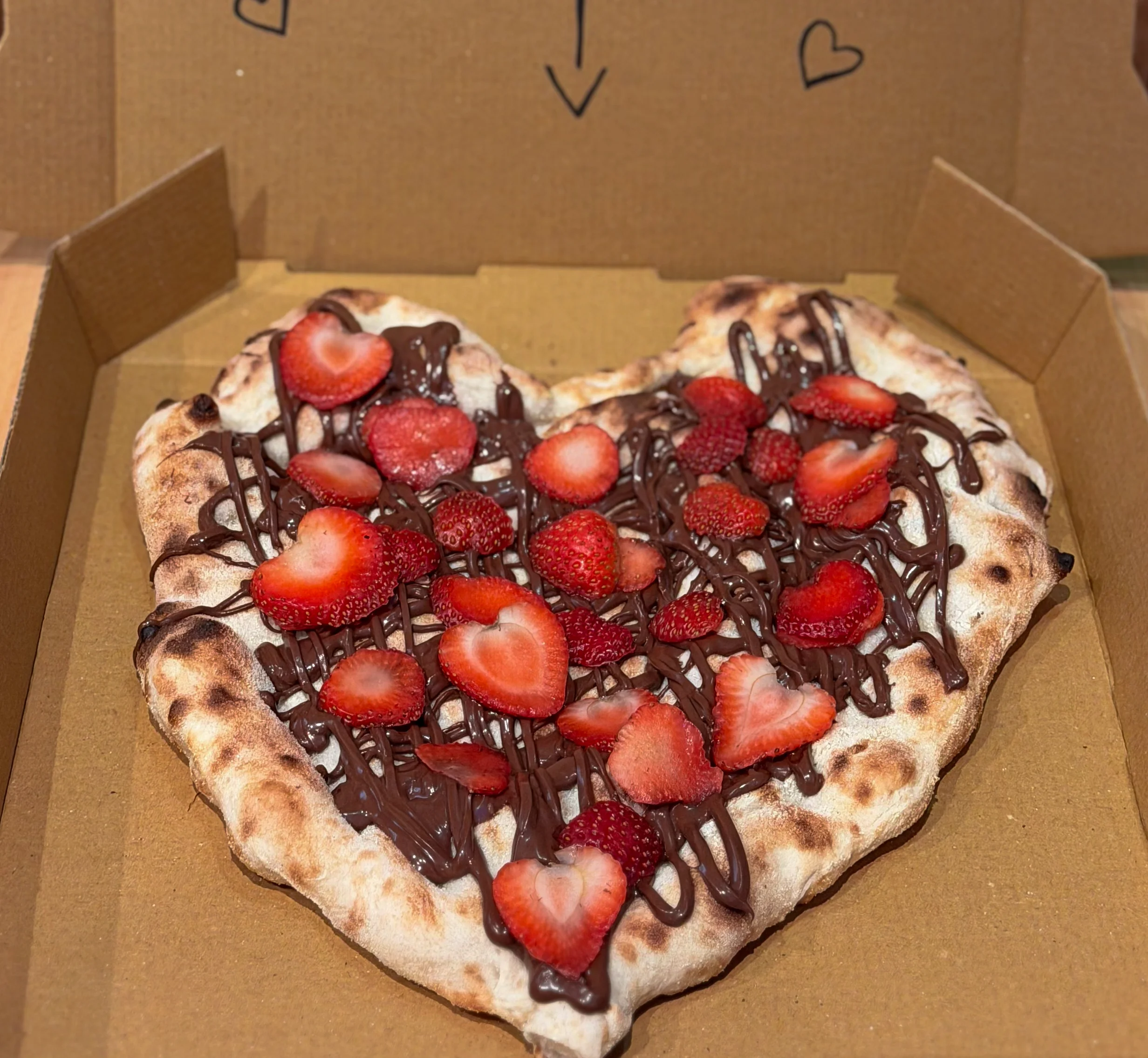 Heart-shaped dessert pizza with strawberries and chocolate