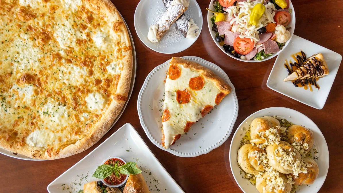Delicious pepperoni pizza with fresh salad and desserts on a wooden table