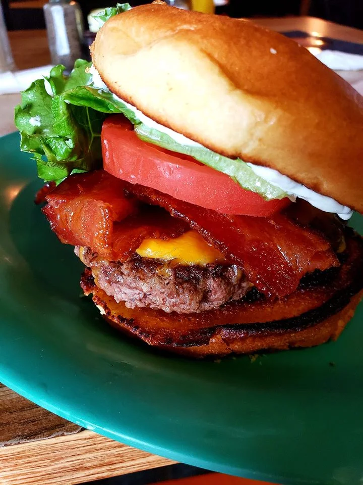 Juicy American cheeseburger with bacon and fresh toppings