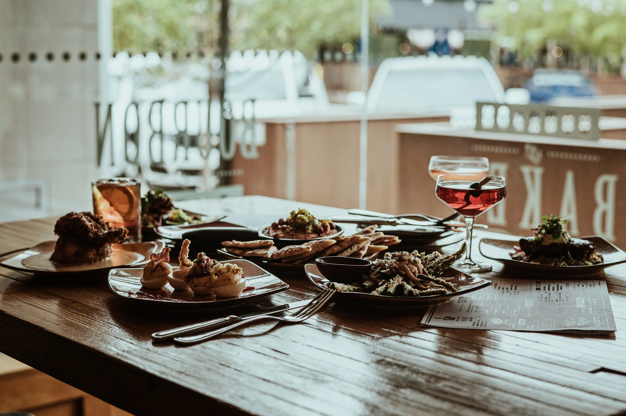 A table with various dishes and drinks in a restaurant setting.