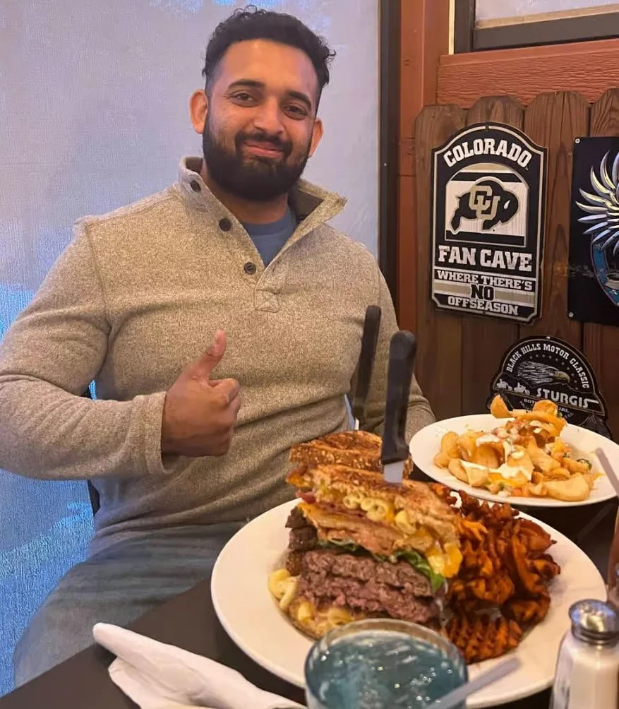 Giant burger stack with fries in a casual dining setting